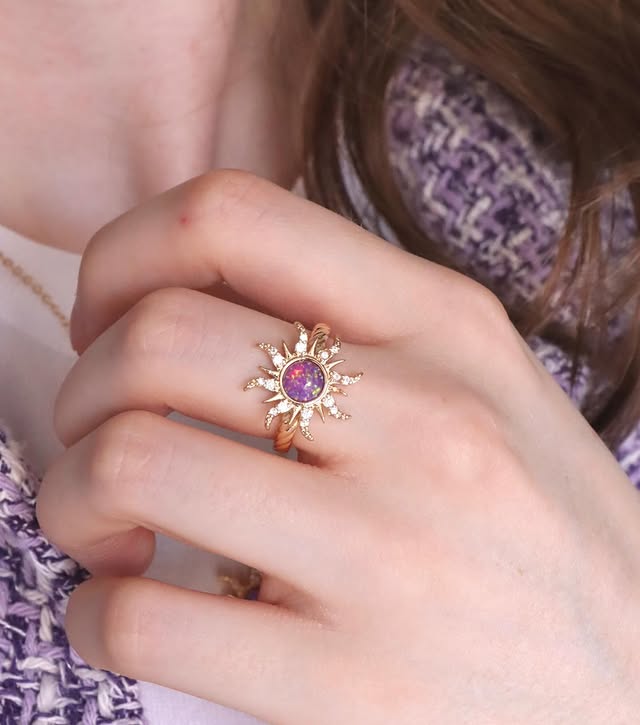 Anillo de sol ajustable en tono dorado, con un cristal morado central y circones en los rayos, inspirado en la princesa Rapunzel.