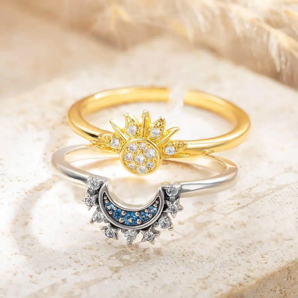 Un par de anillos ajustables, uno en tono dorado que representa el sol y otro en tono plateado que representa la luna.