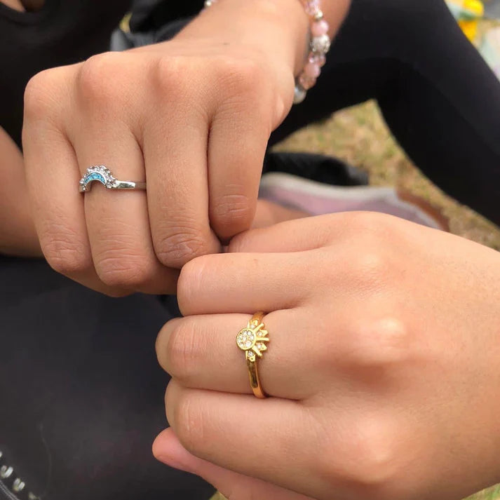 Un par de anillos ajustables, uno en tono dorado que representa el sol y otro en tono plateado que representa la luna. pareja