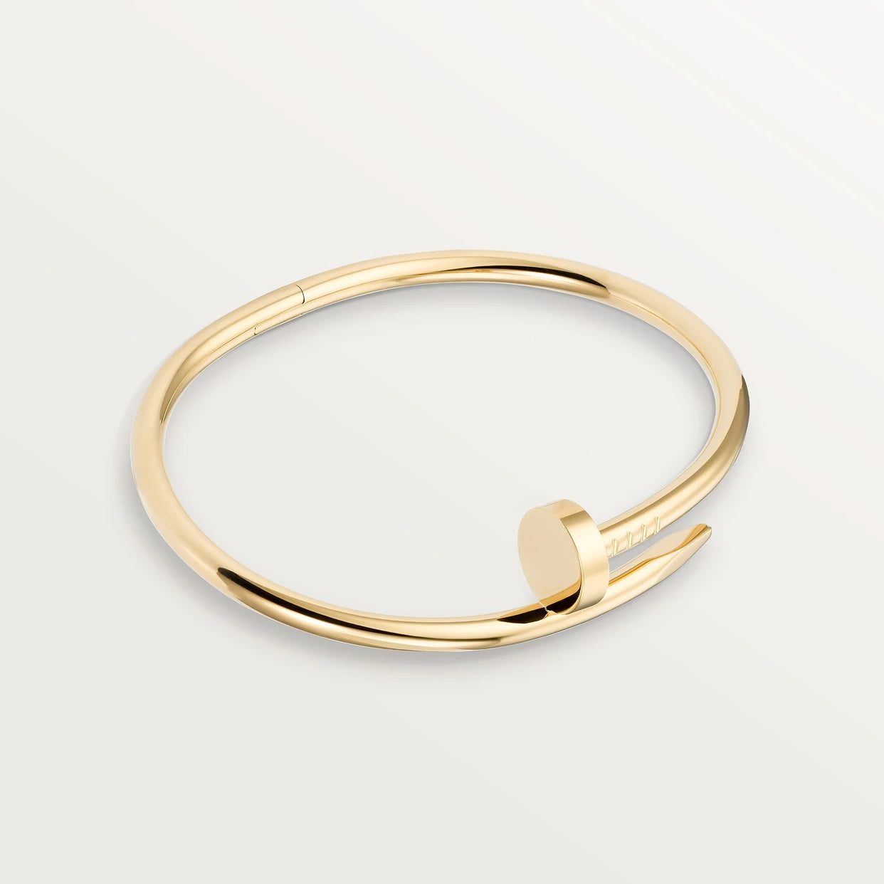 Brazalete estilo clavo en tono dorado, hecho de acero inoxidable y con baño de oro brillante.