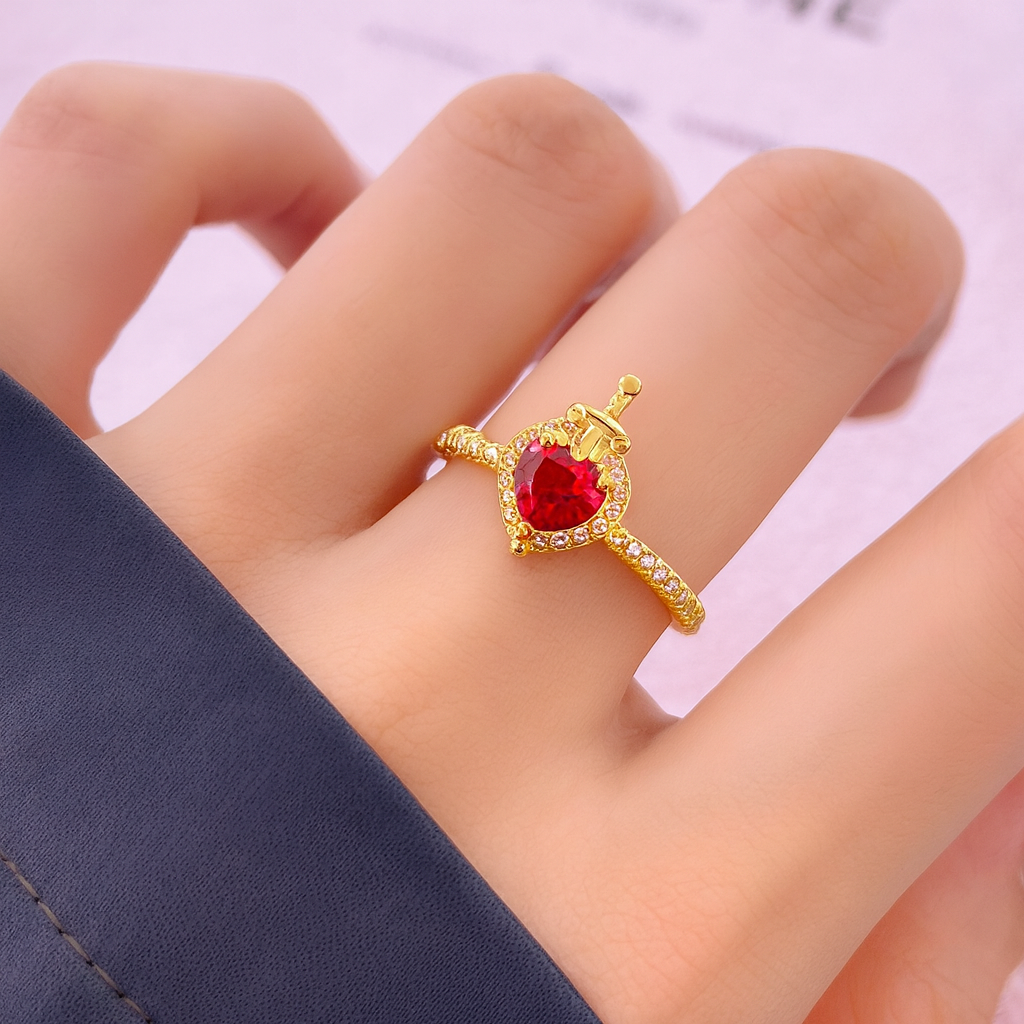 Anillo de la Reina Malvada de tono dorado con un cristal de corazón rojo y un detalle de corona.