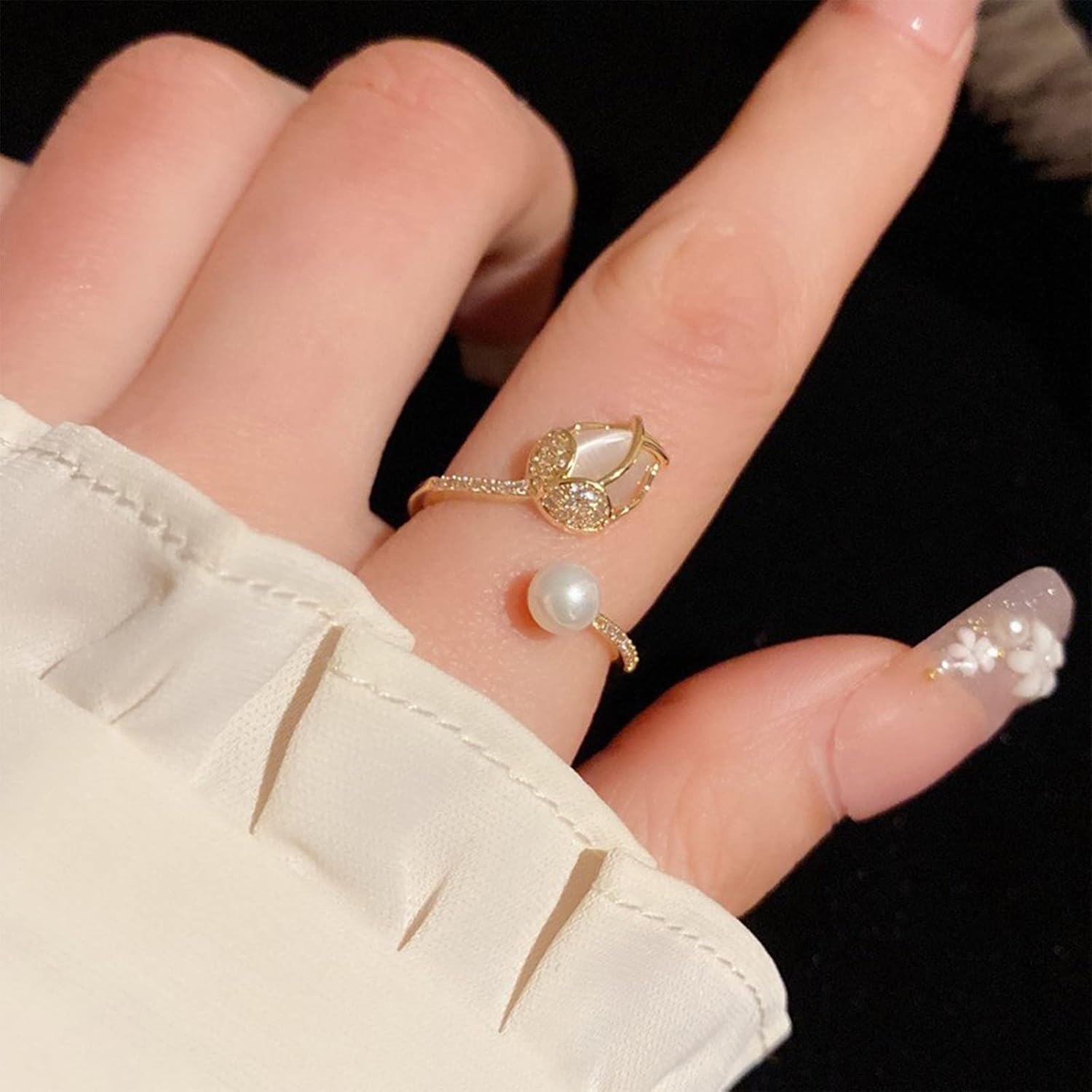Primer plano de un anillo de flor de tulipán en color oro, mostrando el detalle de los pétalos y la perla.