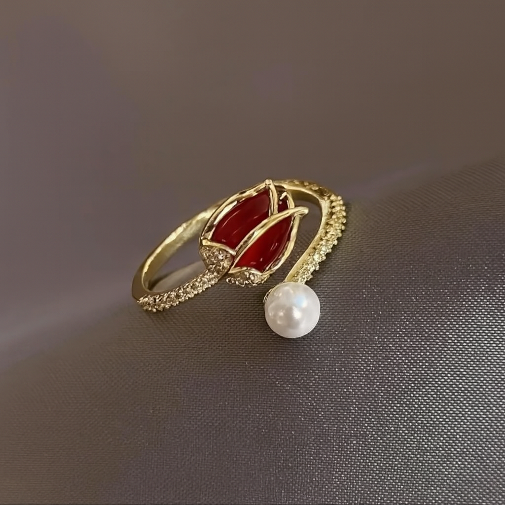 Anillo ajustable de tulipán con un acabado dorado, una perla en la base y el pétalo de la flor en color rojo.