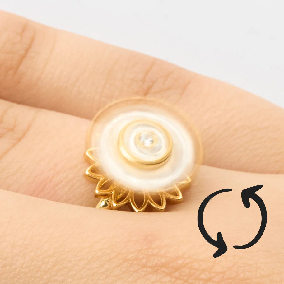 Primer plano de un anillo de girasol con el centro y pétalos que giran, diseñado para aliviar el estrés.