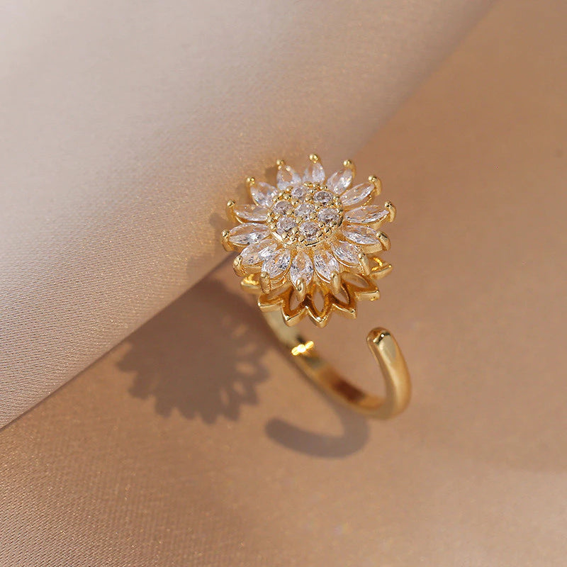 Segundo plano de un anillo de girasol con el centro y pétalos que giran, diseñado para aliviar el estrés.