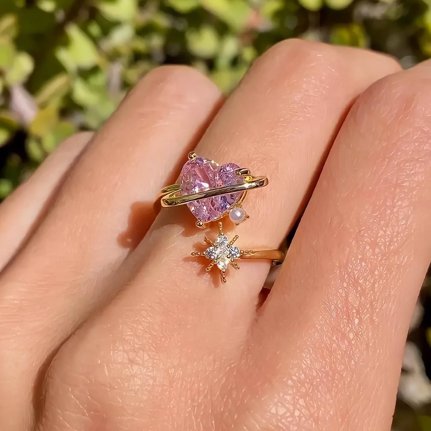 Anillo ajustable del Corazón Cósmico en acabado dorado con piedras en forma de corazón y estrellas. rosa