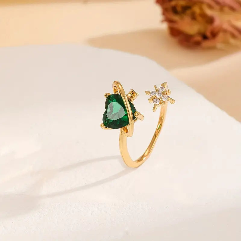 Anillo ajustable del Corazón Cósmico en acabado dorado con piedras en forma de corazón y estrellas. verde esmeralda