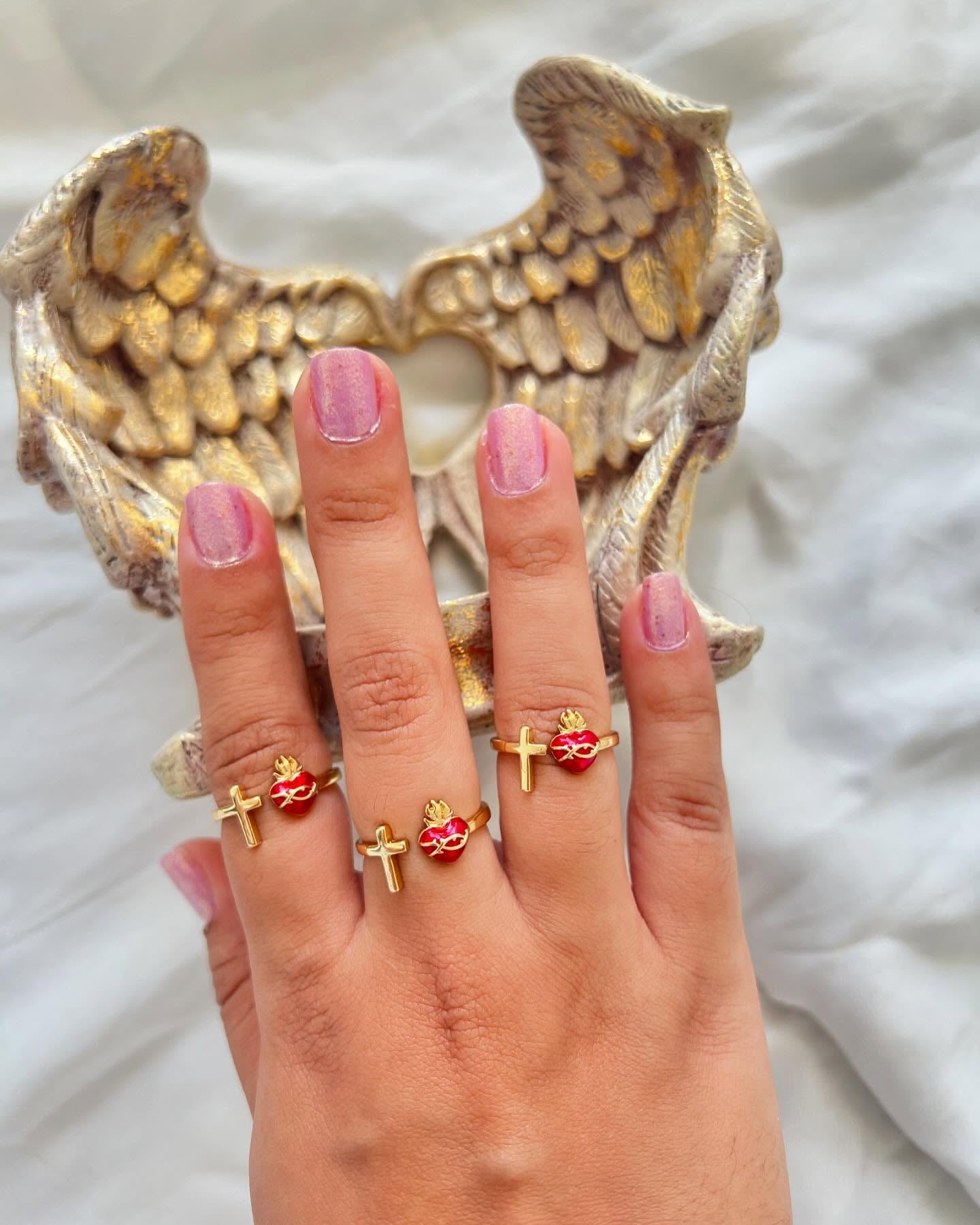 Primer plano del anillo, mostrando el detalle de la cruz y el corazón esmaltado con su corona de espinas.