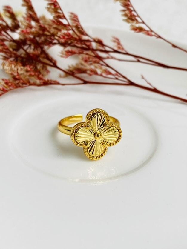 Anillo de acero inoxidable en tono dorado con un dije de trébol dorado, inspirado en Van Cleef.