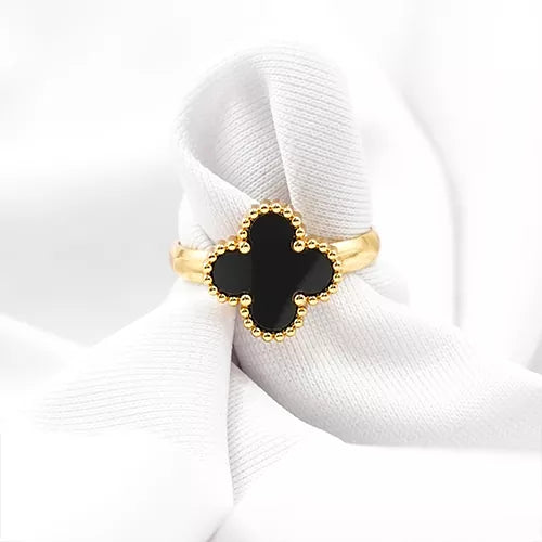 Anillo de acero inoxidable en tono dorado con un dije de trébol negro, inspirado en Van Cleef.