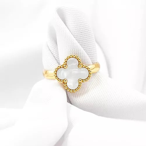 Anillo de acero inoxidable en tono dorado con un dije de trébol blanco, inspirado en Van Cleef.