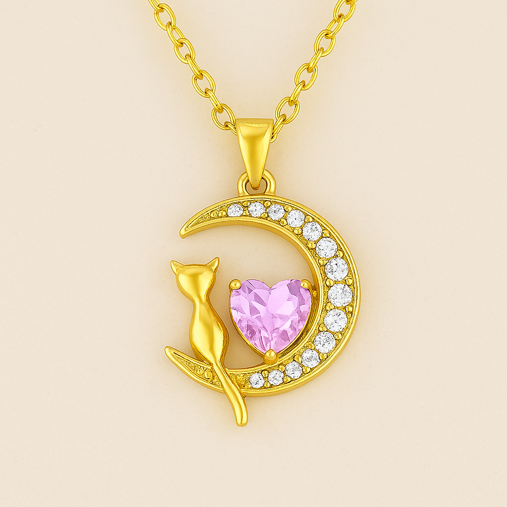 Collar con dije de gatito sentado en una luna, con un corazón central de cristal rosa  y acabado dorado.