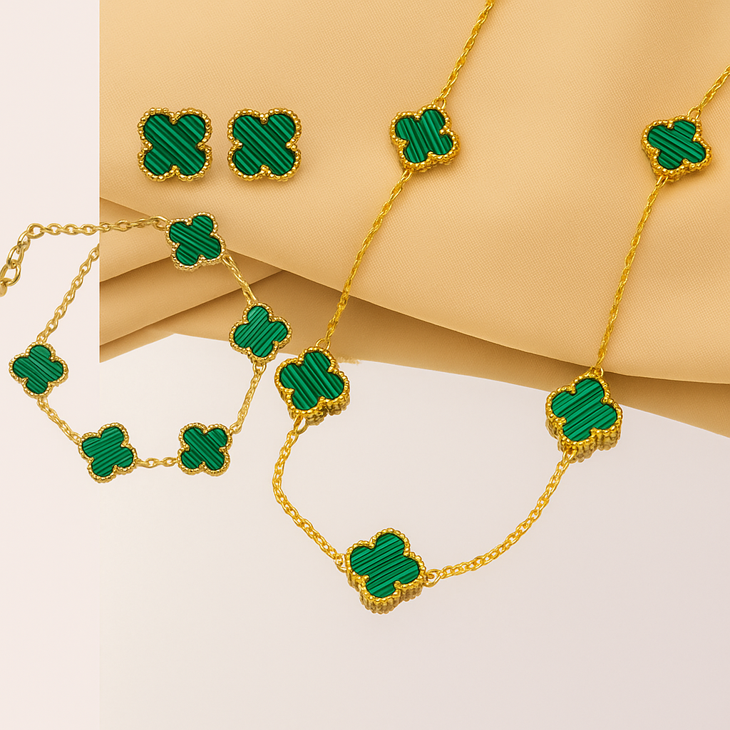 Set de joyería de trébol en tono dorado y verde que incluye collar, pulsera y aretes a juego.