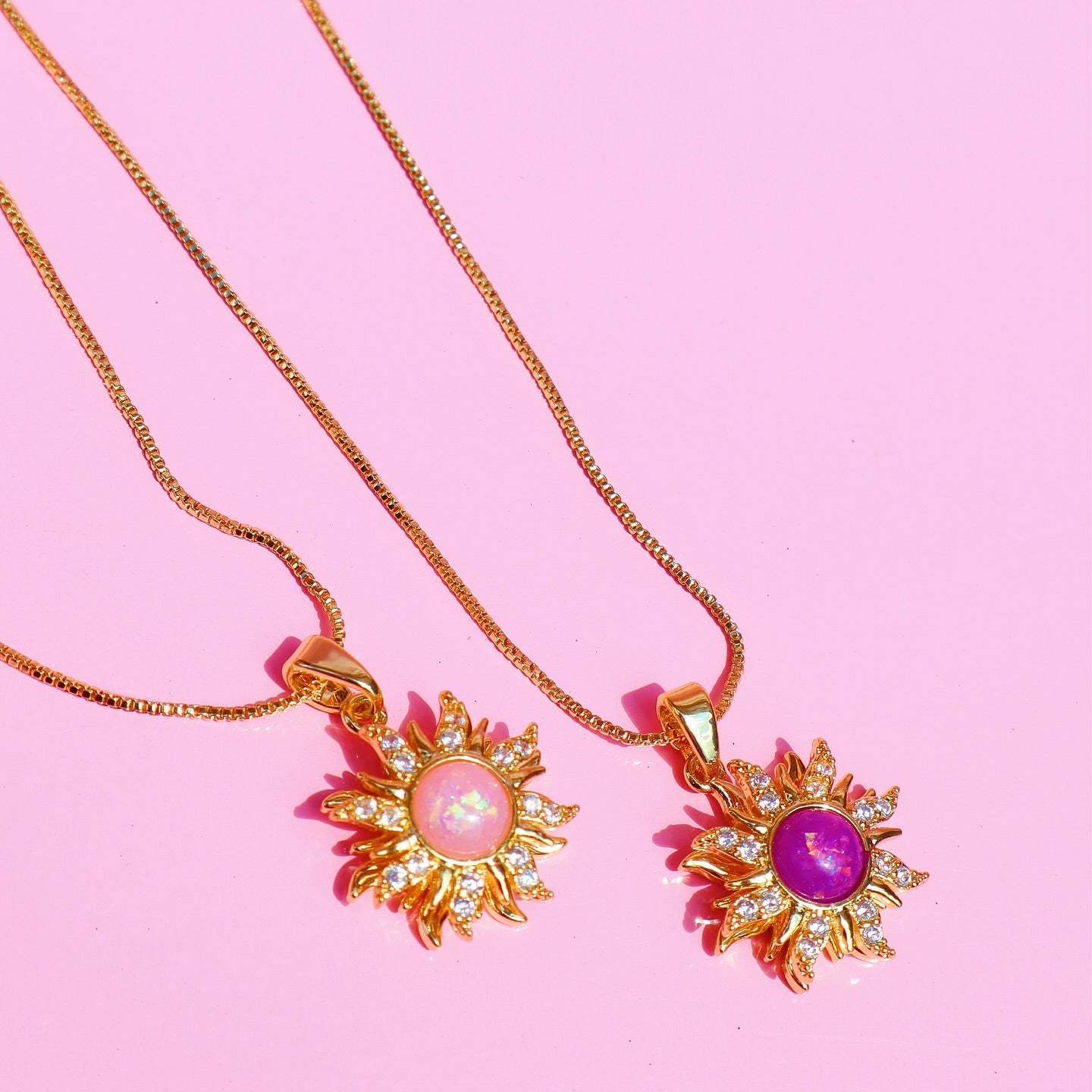 Collar de sol giratorio con un centro brillante de color púrpura y rayos adornados con circones.