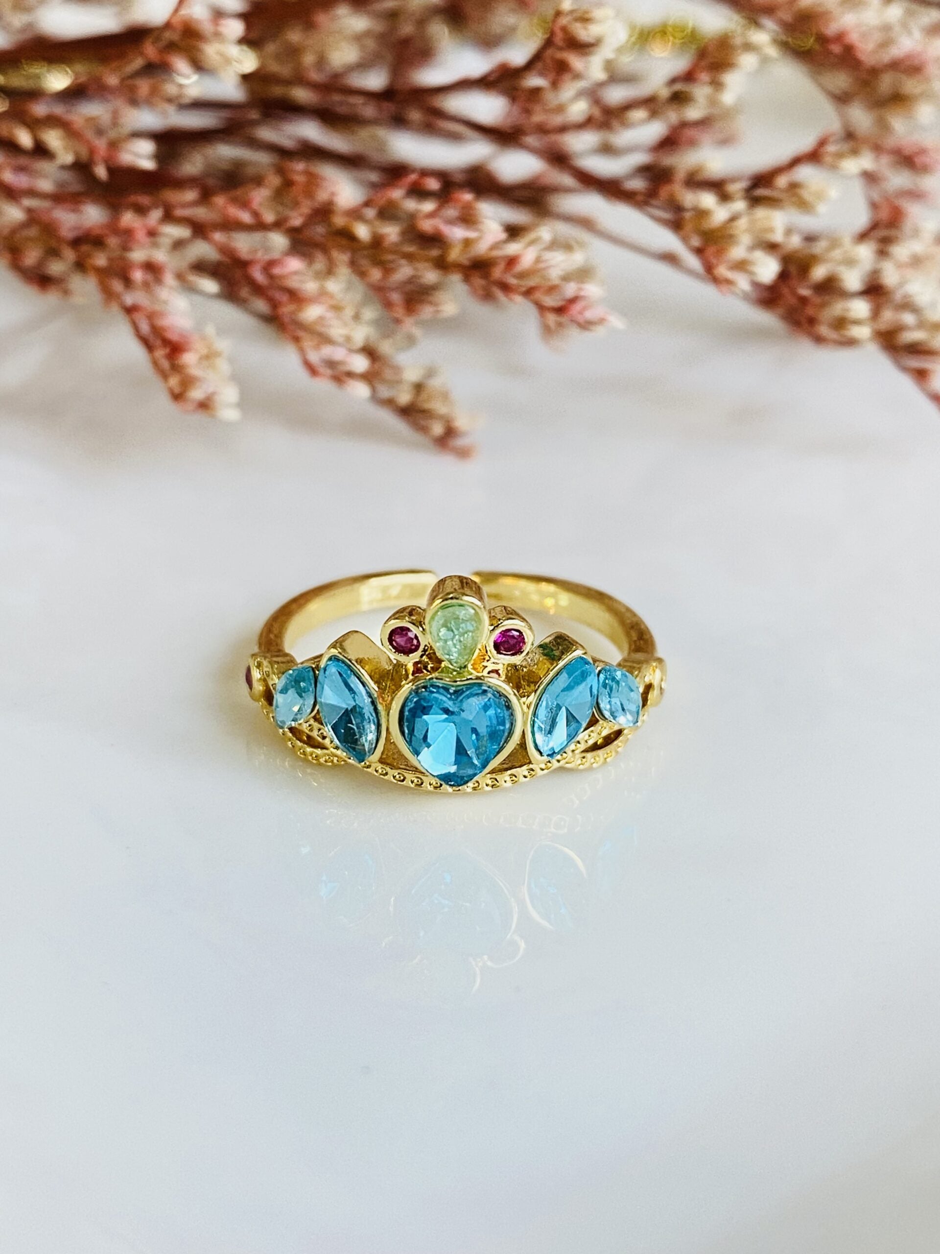 Anillos de princesa con diseño de corona, en una mano, mostrando cómo se ven al ser usados.