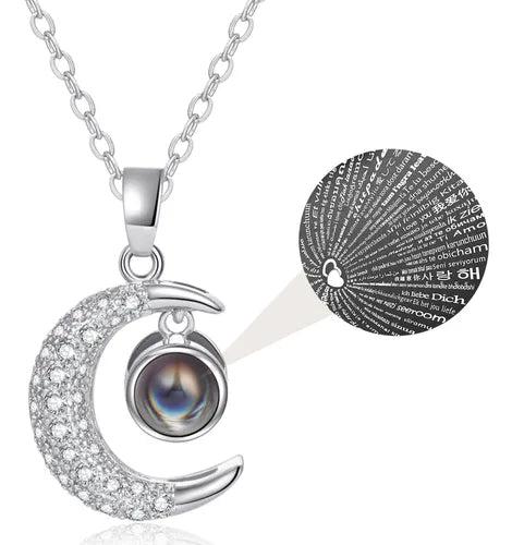 Collar de luna con acabado dorado y circonias, con un dije central que proyecta "Te Amo" en 100 idiomas.