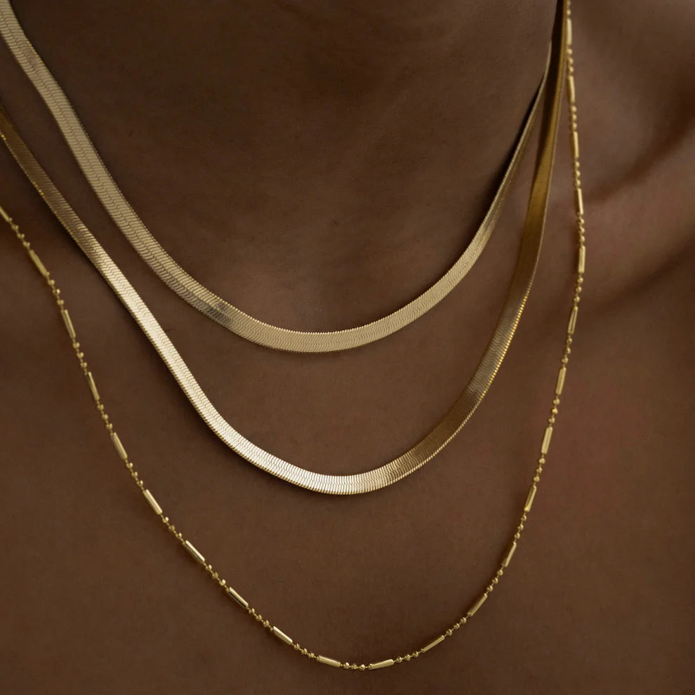 Primer plano de un Choker Tejido Egipcio de Joyería Sajem en un cuello, mostrando el tejido de la cadena y el brillo del metal.