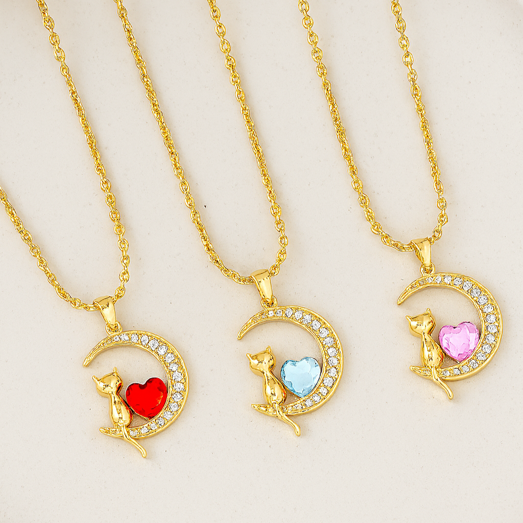 Tres collares de gatito en la luna, cada uno con un corazón de diferente color: rojo, azul y rosa.