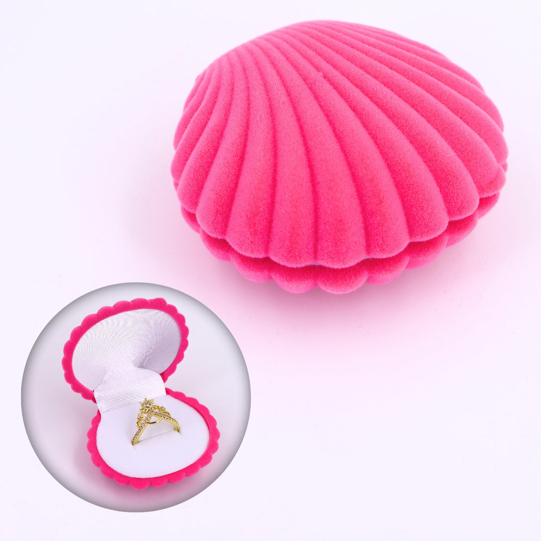 Caja de regalo rosa en forma de concha de mar aterciopelada, ideal para guardar un anillo de compromiso.