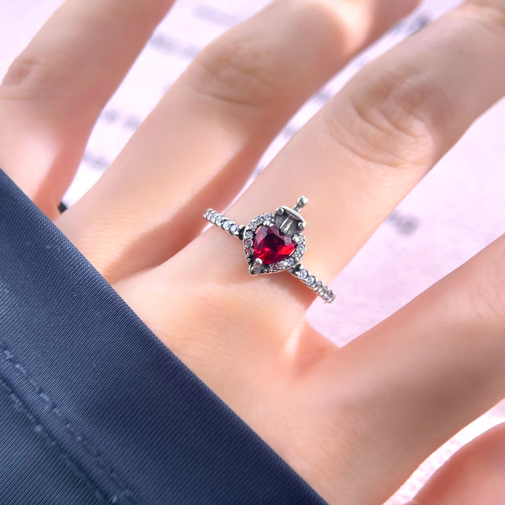 Anillo de la Reina Malvada en acabado dorado y plateado, con un corazón rojo y una corona.

