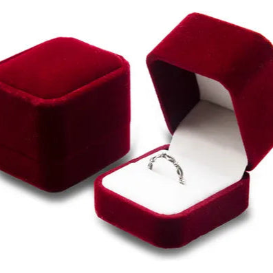 Primer plano de la caja de regalo de terciopelo roja con forma de rosa.

