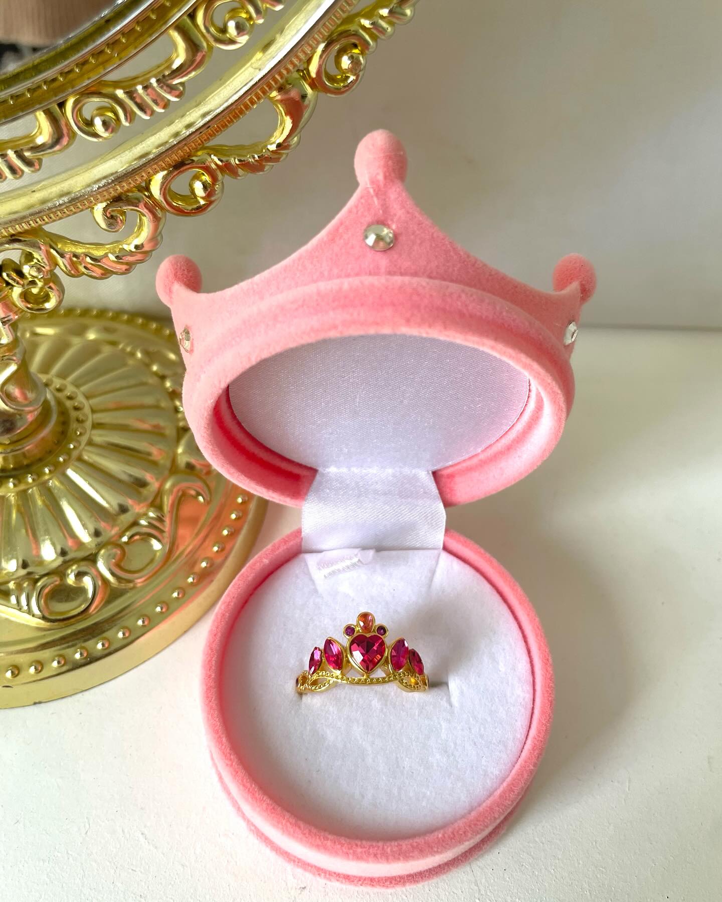 Vista del exterior aterciopelado de una caja de regalo con forma de corona de princesa.