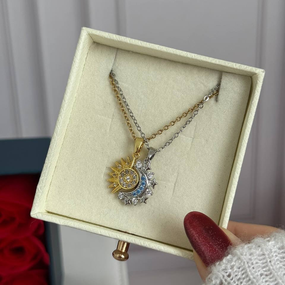 Primer plano de los dijes de sol y luna para pareja, mostrando el detalle de las piedras y el acabado del metal.