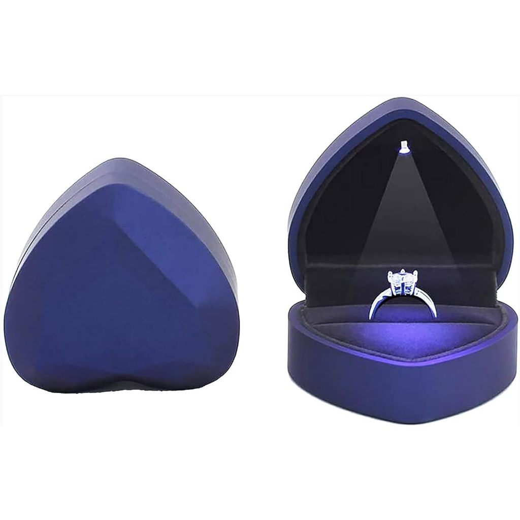 Caja de regalo azul con forma de corazón facetado, con una luz LED interna que ilumina un anillo.